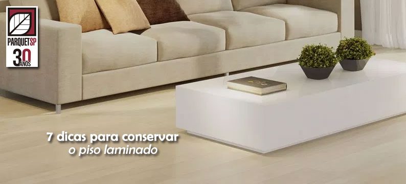 Ao fundo da imagem, há uma sala com piso laminado.