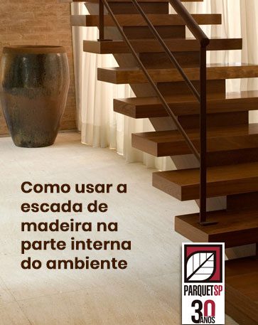Ao fundo da imagem, há uma escada de madeira em um ambiente interno.