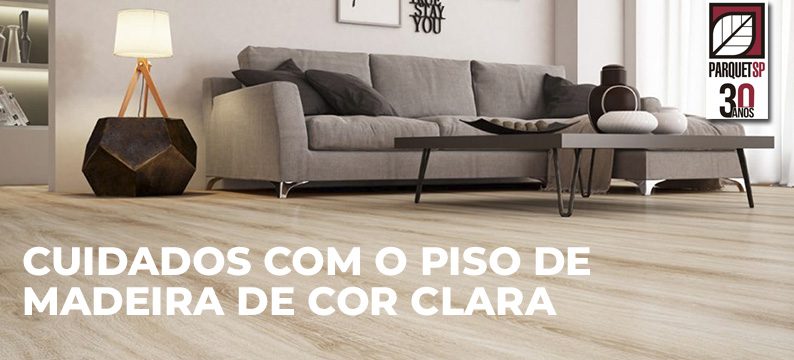 Ao fundo da imagem, há uma sala de estar com piso de madeira de cor clara.
