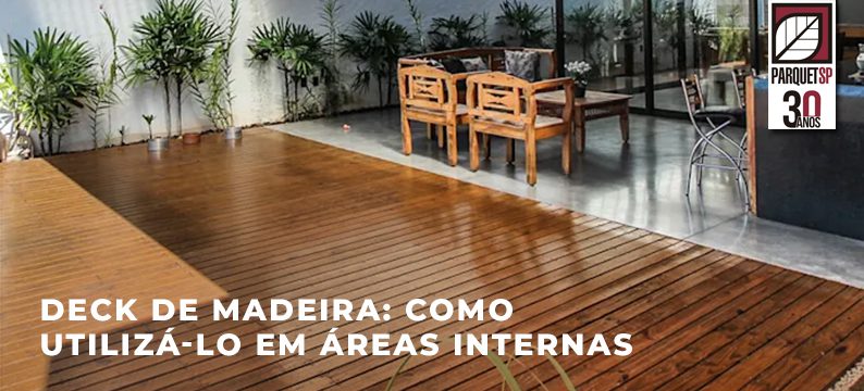 Ao fundo da imagem, há um deck de madeira em área interna.