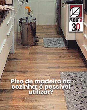 Ao fundo da imagem, há uma cozinha com piso de madeira.