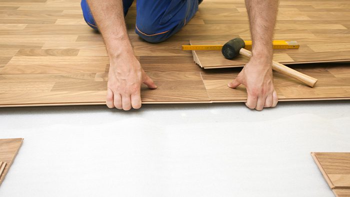A imagem mostra a aplicação de um piso parquet.