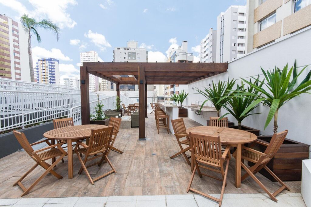 Ao fundo da imagem, há um terraço com deck de madeira.