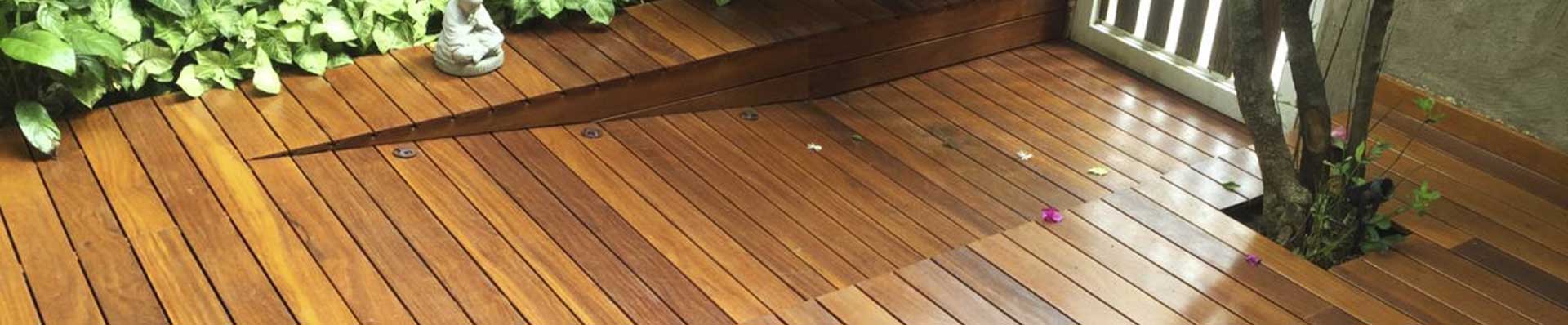 Imagem ilustra um Deck de madeira, aplicado em um jardim.
