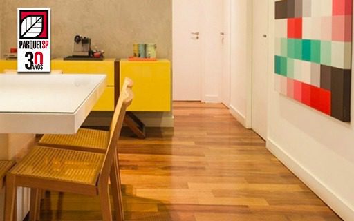 Ao fundo da imagem, há uma sala de jantar com piso de madeira e um móvel amarelo.