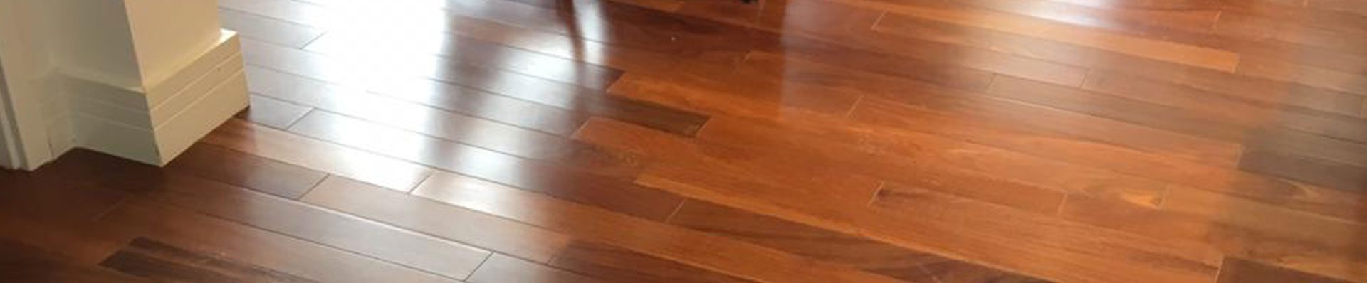 Ao fundo da imagem, há uma sala de jantar com o piso de madeira cumaru.