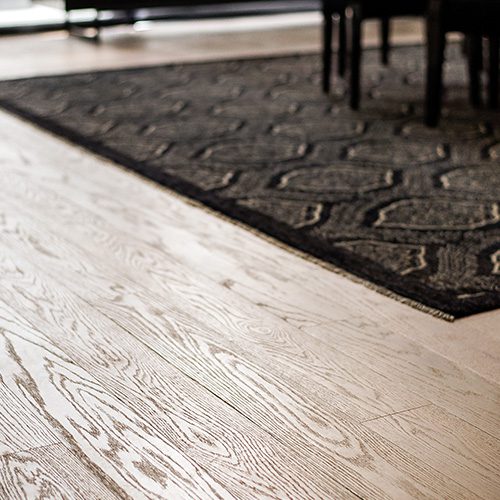 Piso de madeira clara com veios aparentes em destaque, representando elegância, durabilidade e tradição na decoração de interiores.