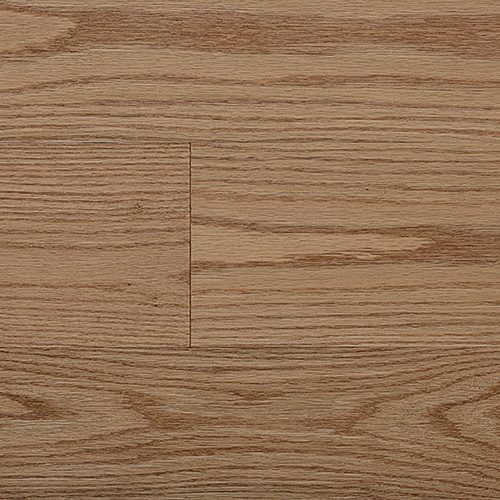 Close-up de um piso de madeira maciça com textura natural e tonalidade amadeirada, destacando os veios e padrões que valorizam o acabamento.