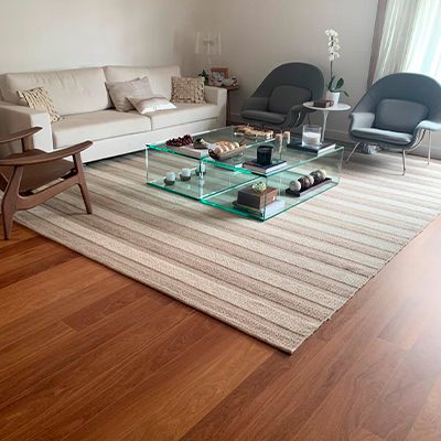 A imagem mostra uma sala de TV com assoalho de madeira.