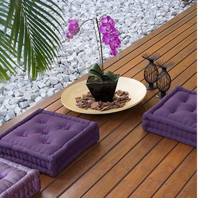 A imagem mostra um vaso de flor em um deck de madeira.