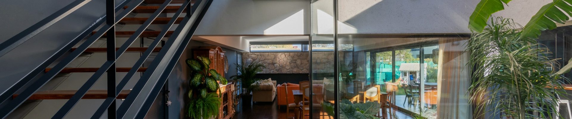 Escada de madeira com estrutura metálica em ambiente residencial moderno, integrando design, iluminação natural e conforto.