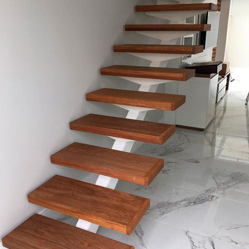 Escada de madeira flutuante com degraus robustos e acabamento elegante, destacando-se sobre piso branco marmorizado.