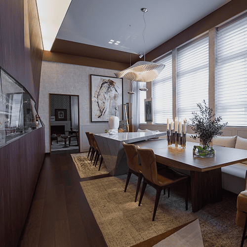 Sala de jantar sofisticada com piso de madeira escura, mesa ampla, cadeiras estofadas, iluminação pendente e decoração elegante.