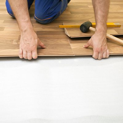 A imagem mostra a aplicação de um piso parquet.