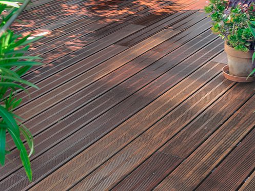 Imagem ilustra um deck de madeira no jardim de inverno