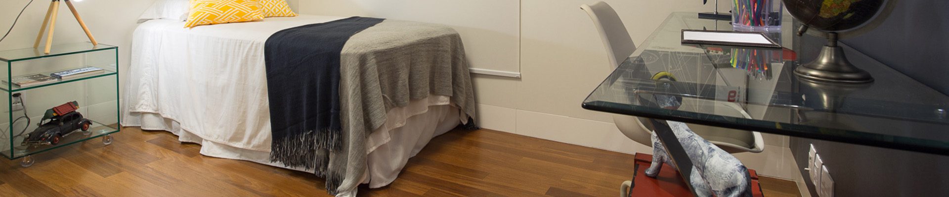 Quarto com piso de madeira cumaru, decoração náutica e mesa de vidro; ambiente moderno e aconchegante.
