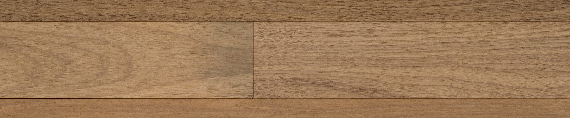Superfície de piso de madeira maciça com tons naturais, destacando sua textura e variação de cores, ideal para ambientes elegantes e aconchegantes.