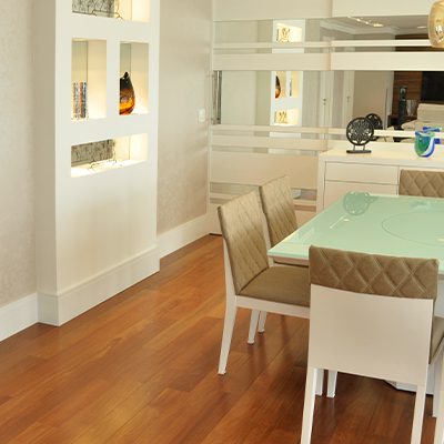 A imagem ilustra uma sala com o piso de madeira maciça.