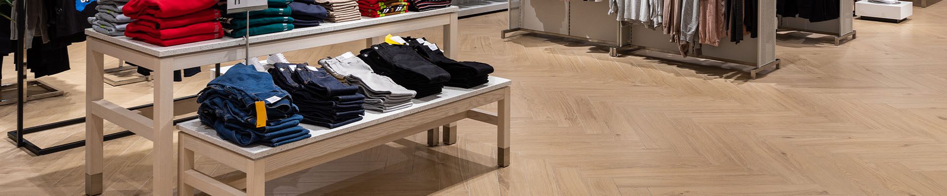 Imagem ilustra uma loja de roupas com piso de madeira