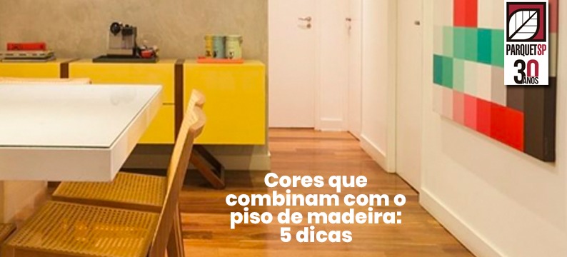 Ao fundo da imagem, há uma sala de jantar com piso de madeira e um móvel amarelo.