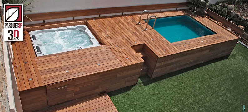 Duas piscinas grandes com área ao redor em deck de madeira
