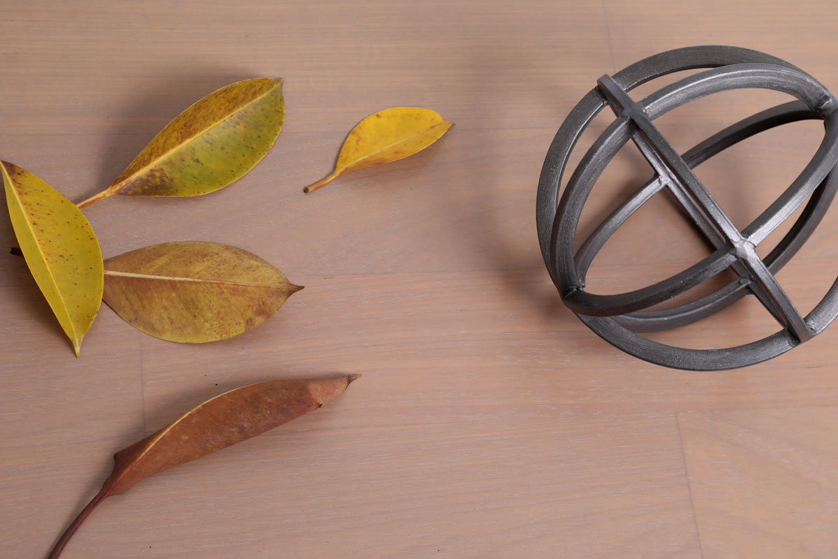 Piso de Madeira Craft Umbra com objeto decorativo de ferro preto e folhas secas | ParquetSP