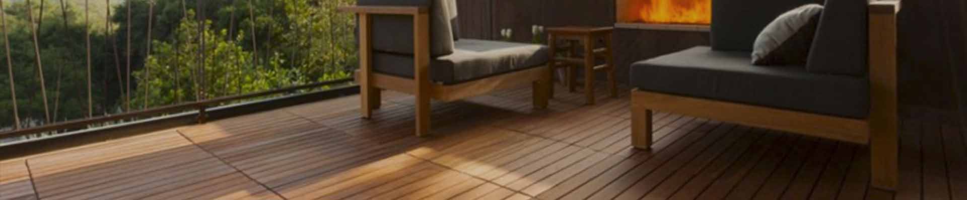 Ao fundo da imagem, há um deck de madeira na varanda.